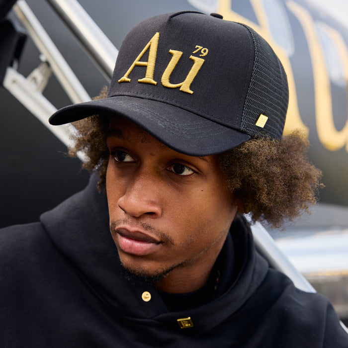 Person wearing an Au signature cap with gold logo on the front