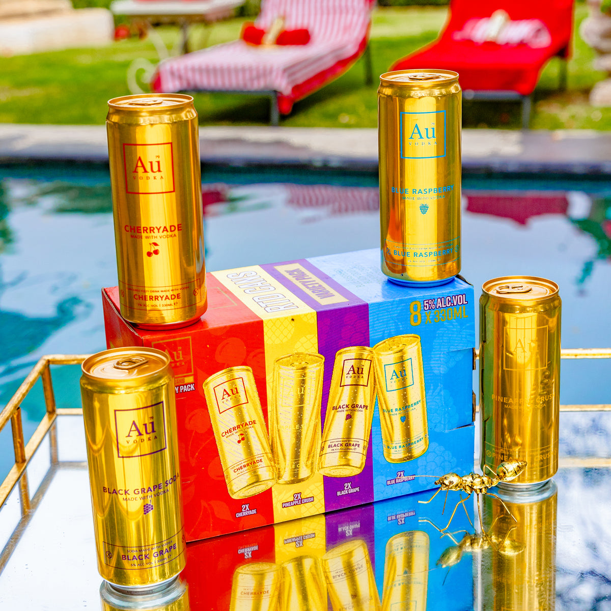 Au Vodka cans in Cherryade, Blue Raspberry, Black Grape, and Pineapple Crush flavors, with an ant figurine
