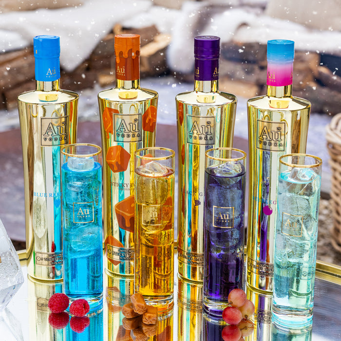 Set of colorful bottles with 'Au' branding on a reflective surface.