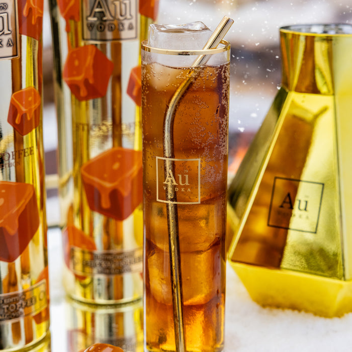 Au Vodka bottle with a cocktail and ice cubes on a reflective surface