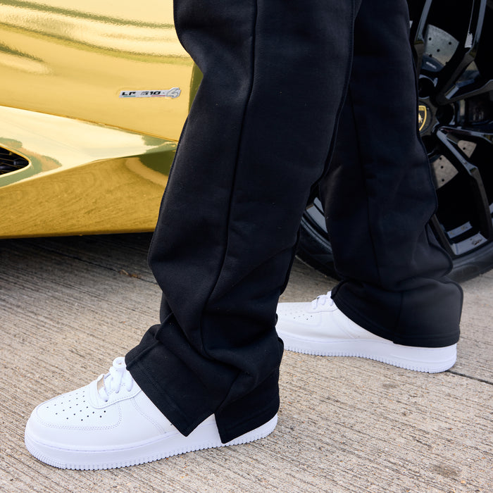 Person wearing black joggers and white shoes