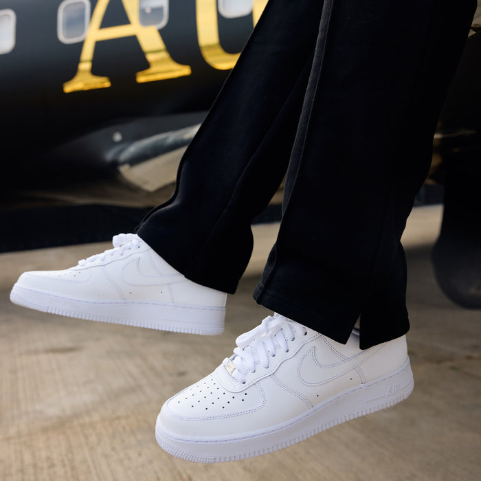 White sneakers worn with black joggers 